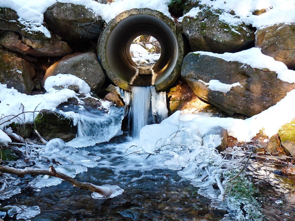 Das Wasser des kleinen Bachs ist gefroren und hat schöne Eisskulpturen erschaffen