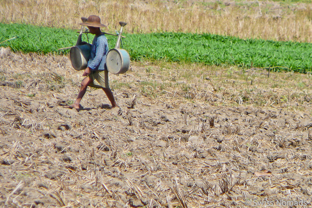 Bauer in Burma beim bewässern auf dem Feld